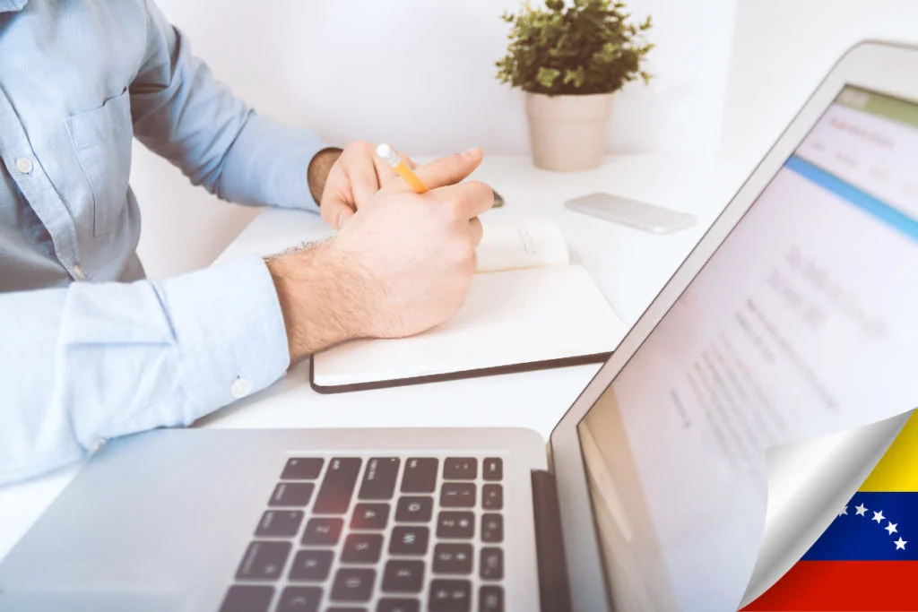 Entrepreneur taking notes next to a laptop while planning a new business